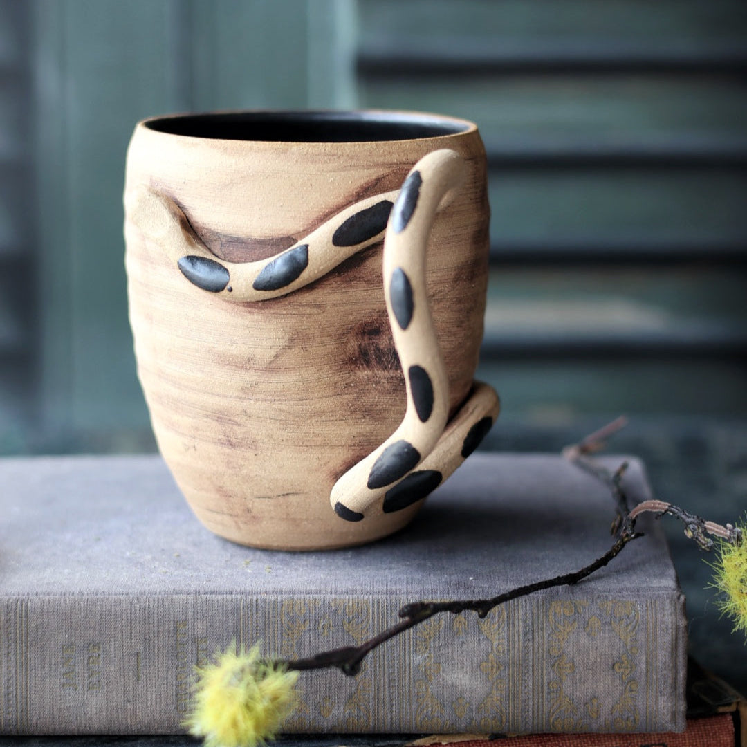 Ceramic mug with a unique design on a stack of books